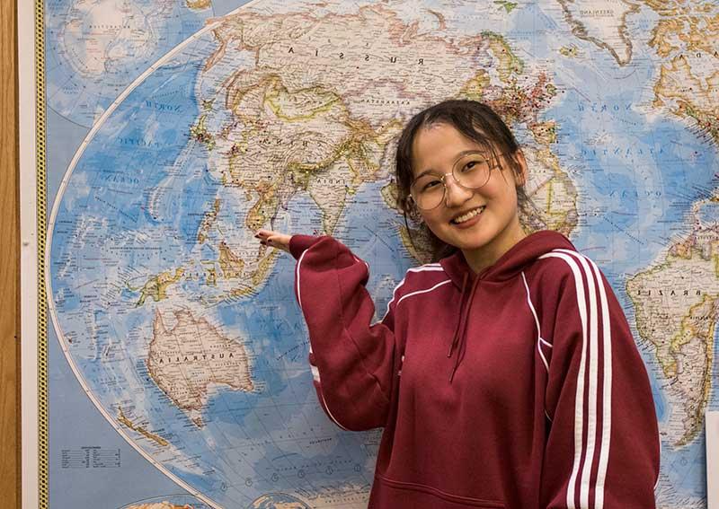 student pointing at map