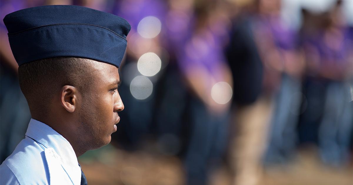 A member of the Air Force stands at attention for a campus even honoring veterans.